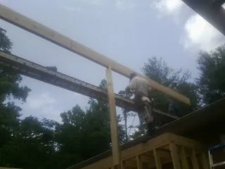 Carpenter setting a ridge beam over a new addition frame — Ice Dam Removal by Roofing Brothers in Wakita