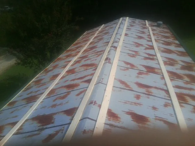 Rusted metal roof panels with new wood purlins before replacement — Storm Damage Roof Repair in Wakita by Roofing Brothers