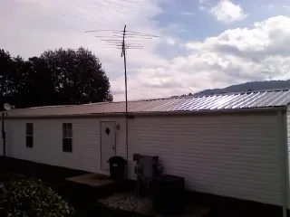 New metal roof on a single wide mobile home with a TV antenna in Wakita