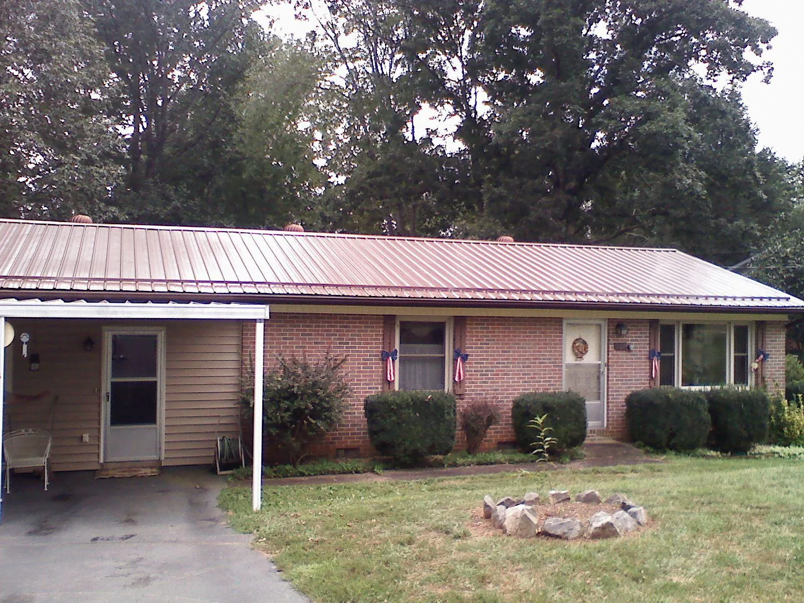 Bronze metal roof and carport on a brick ranch home — Roof Repair work by our crew in Wakita